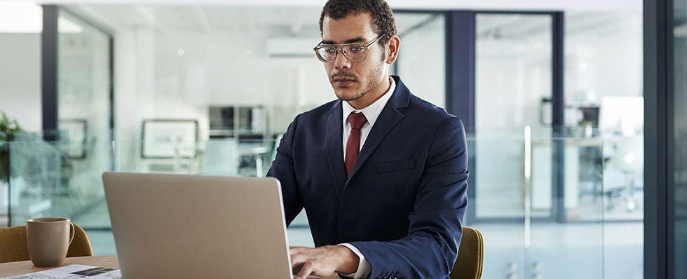Man sitting and looking at his laptop.